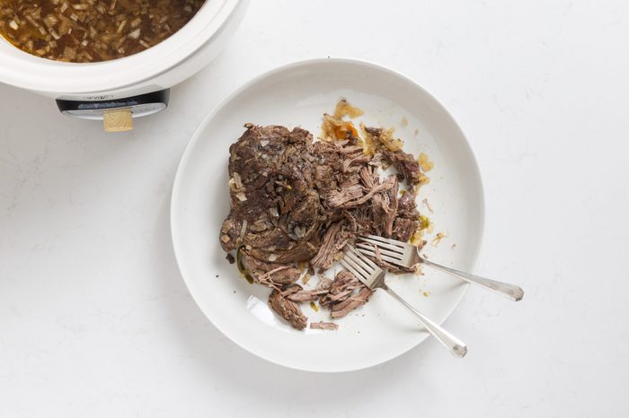 Roast being shredded with forks.