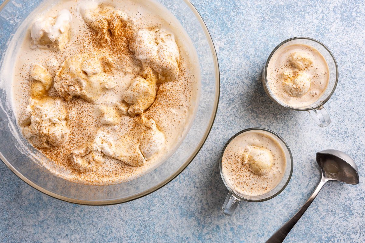 Taste of Home coffee punch recipe photo of ingredients combined into punch bowl filled with vanilla ice cream and served into two glass mugs.