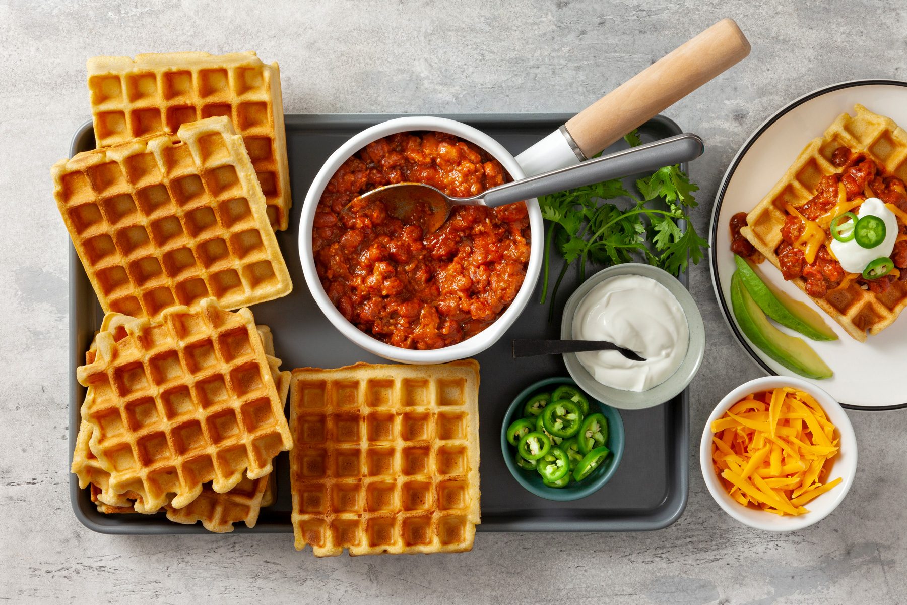 Cornbread Waffles on black serving platter with garnishes on the side