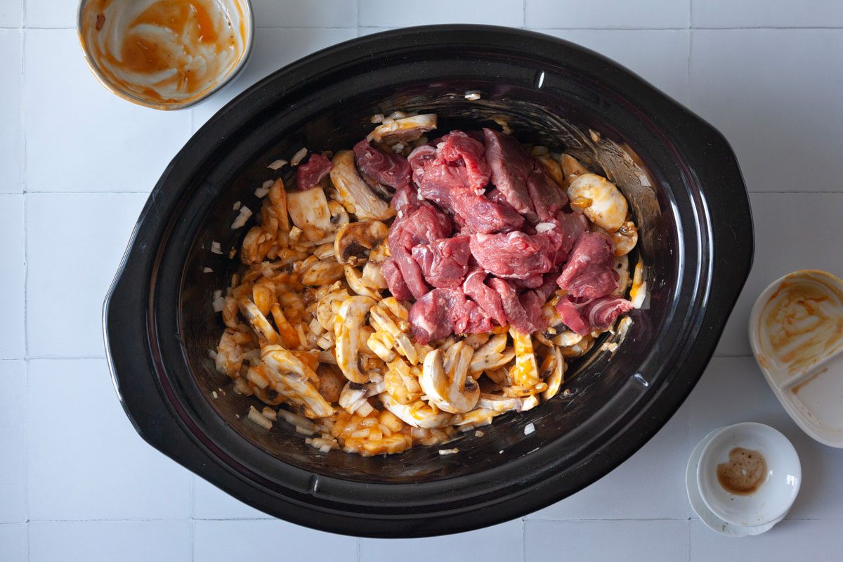 Step 1 of Taste of Home Crockpot Beef Stroganoff is to combine the mushrooms, onions, soup, soy sauce, mustard, Worcestershire sauce, garlic, salt and pepper in the slow cooker before stirring in the steak.
