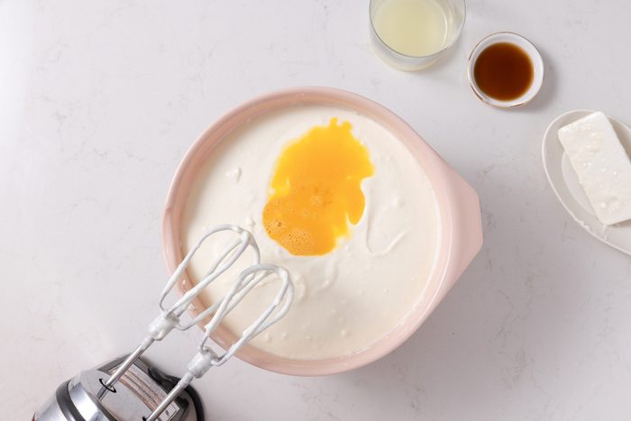 Adding eggs, vanilla extract and lemon juice to the batter.