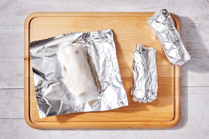 Freezer Breakfast Burritos Step 3- Wrapping burritos in wax + foil prior to freezing