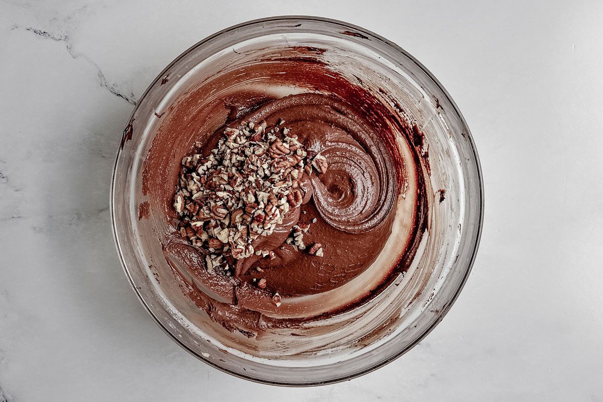 Taste of Home German chocolate cookie batter in a glass bowl on a marble surface.