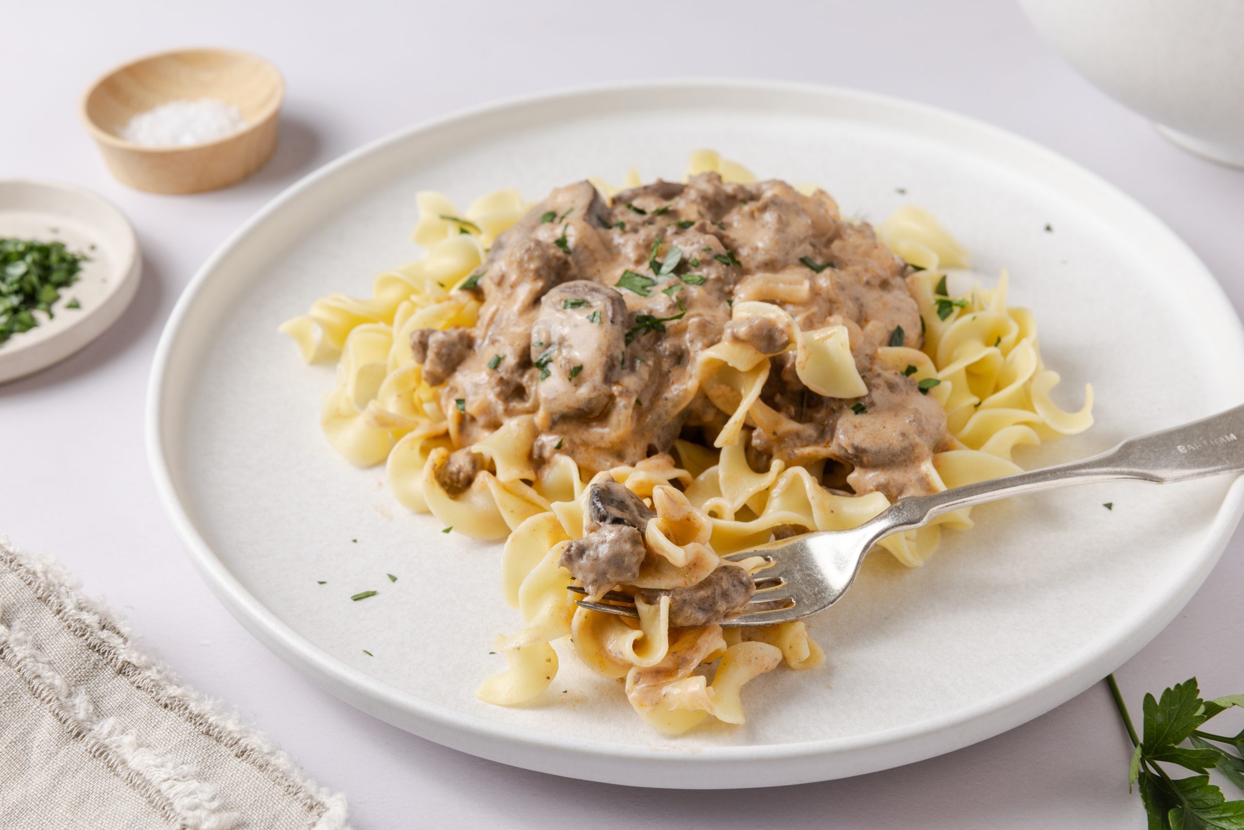 Stroganoff served on plates garnished with fresh parsley.