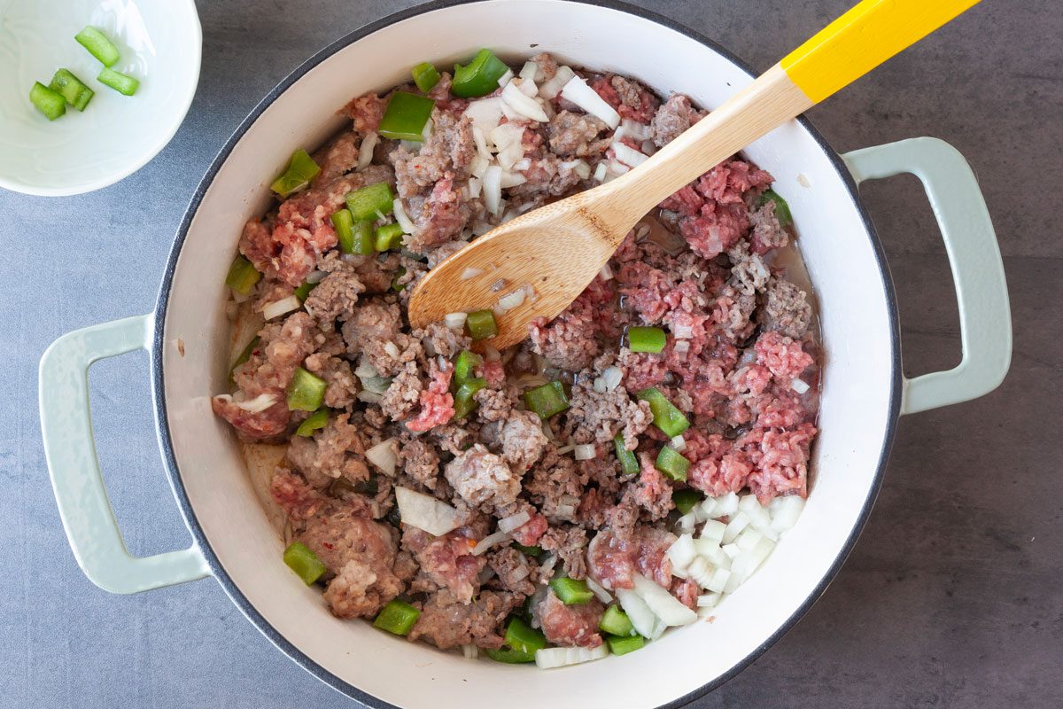 Step 1 of Taste of Home Italian Casserole is to cook the sausage, beef, onion and green pepper until the meat is no longer pink, then drain the grease.