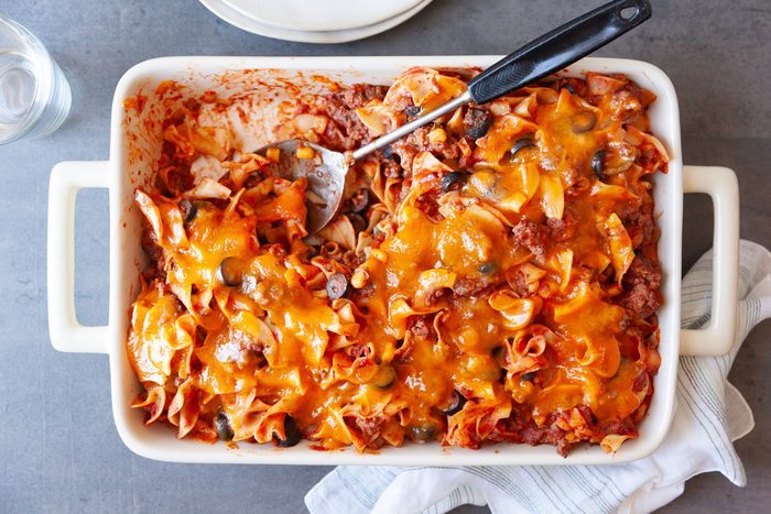 Full yield of Taste of Home Italian Casserole in a white 13x9 baking dish, with a scoop out