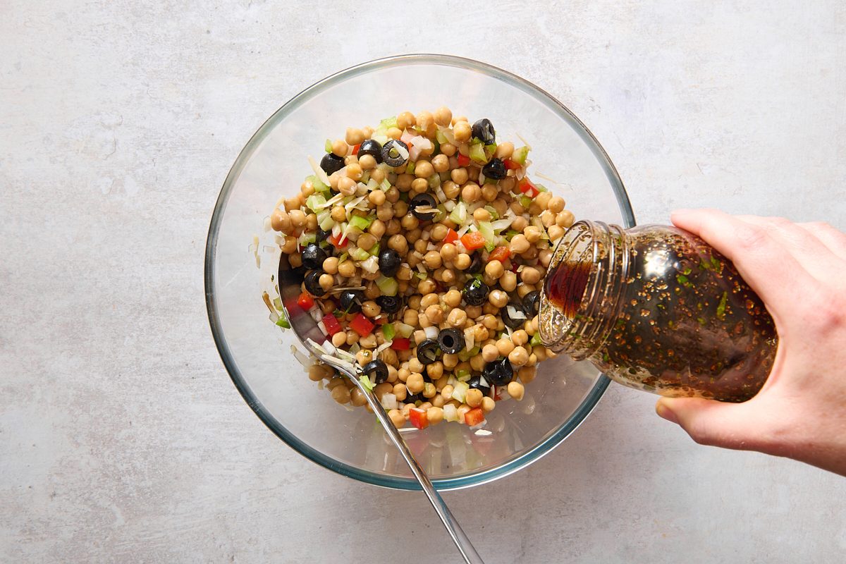 Pouring dressing over the chickpea salad