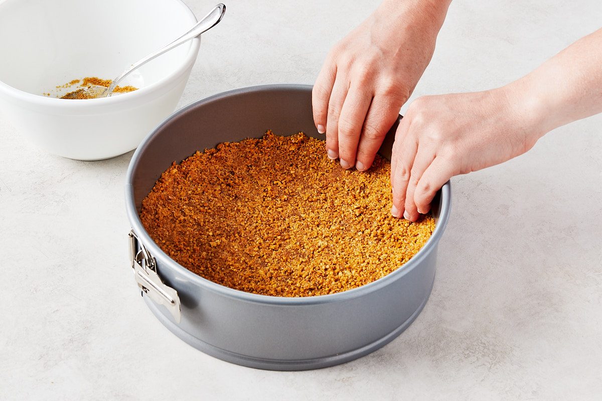 No Bake Lemon Cheesecake Step 1- pressing graham cracker crumbs into springform pan
