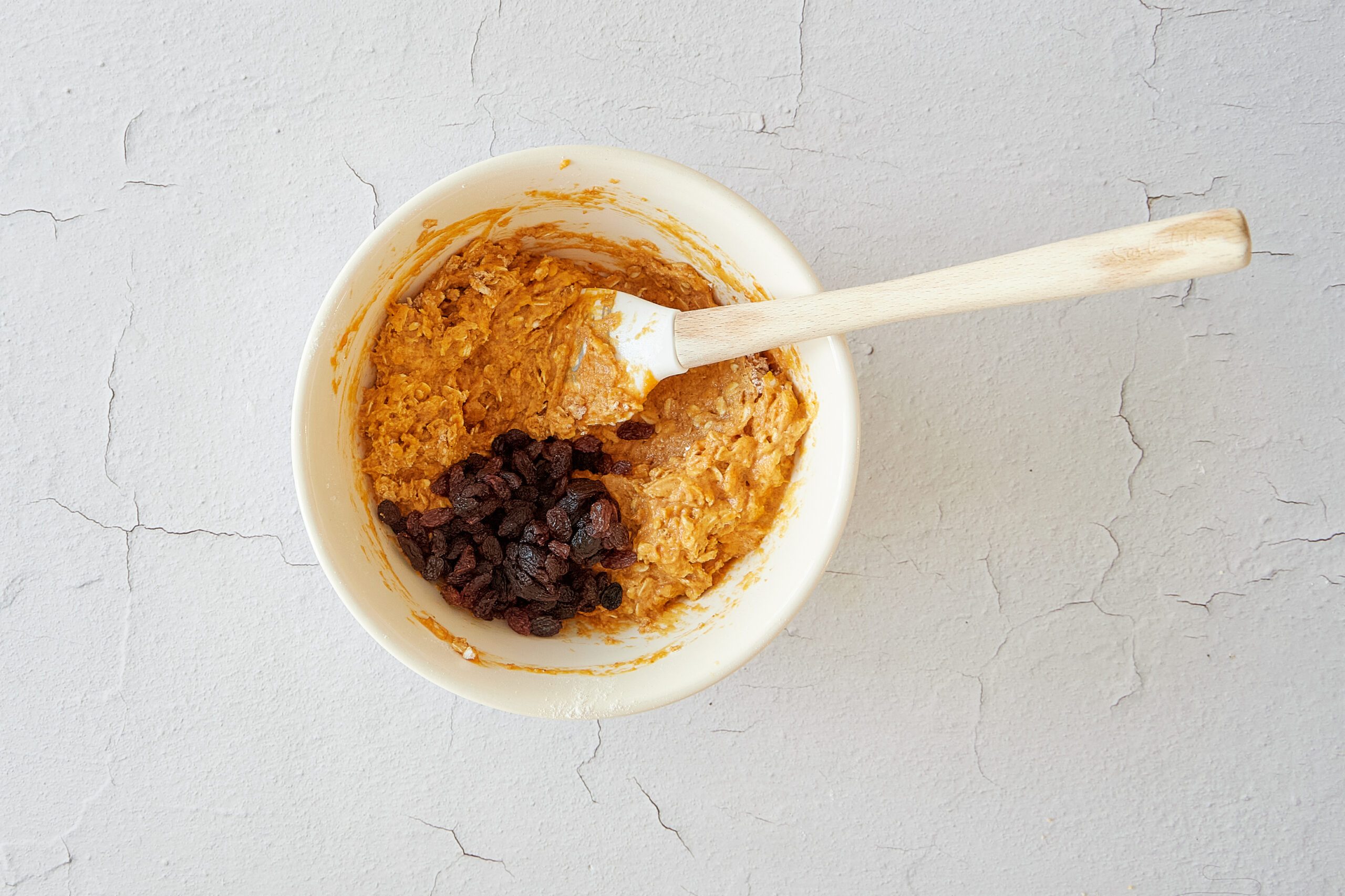 Mix the batter for pumpkin oatmeal muffins.