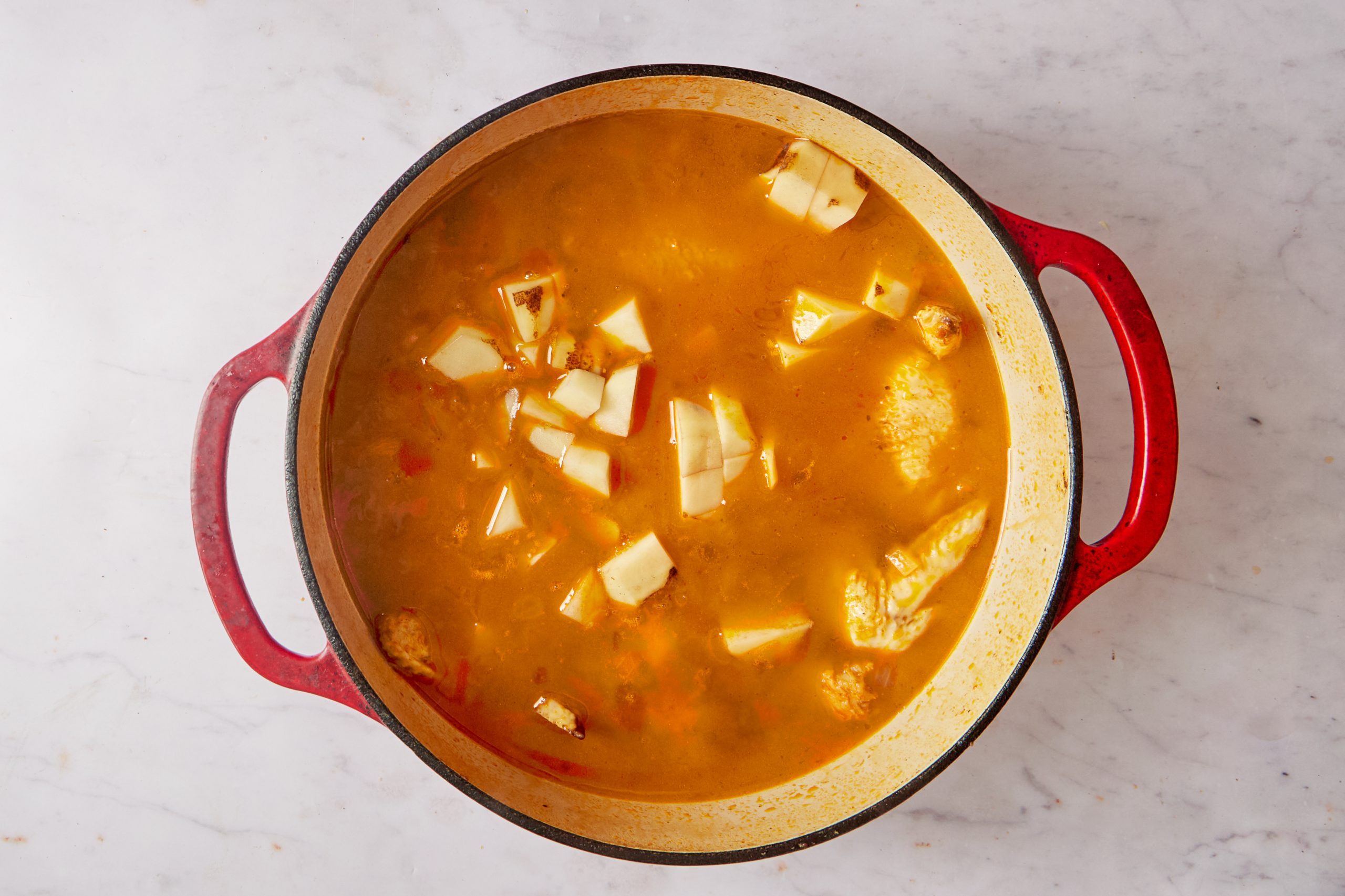 Add the broth to the Spanish chicken soup.