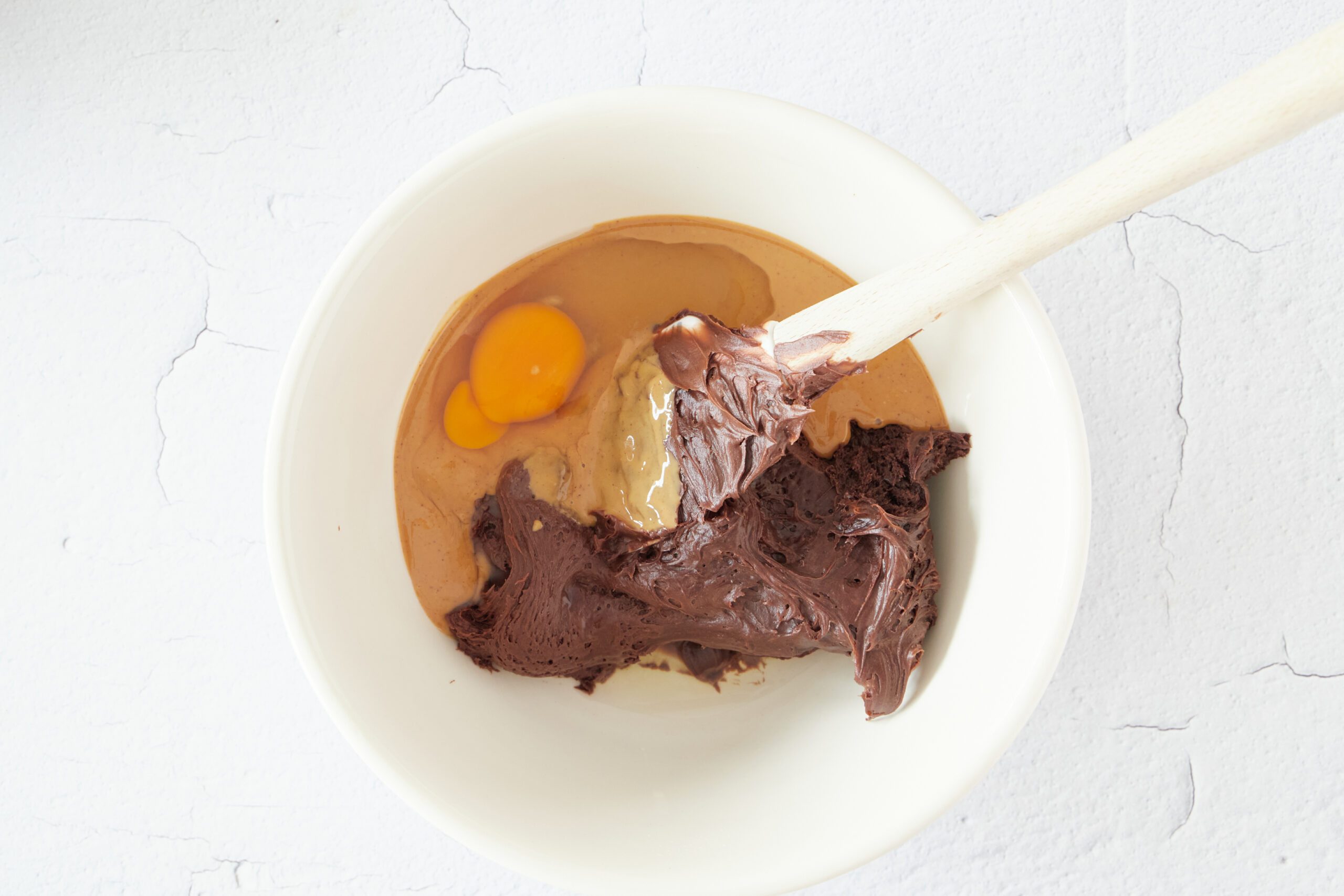 Mix the ingredients for chocolate peanut butter cookies.