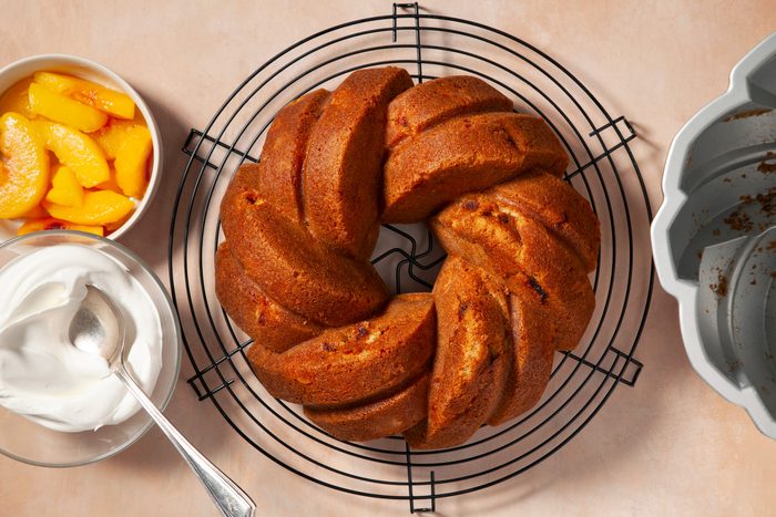 Top view shot of Peach Pound Cake on wire rack with peaches and cream on the side