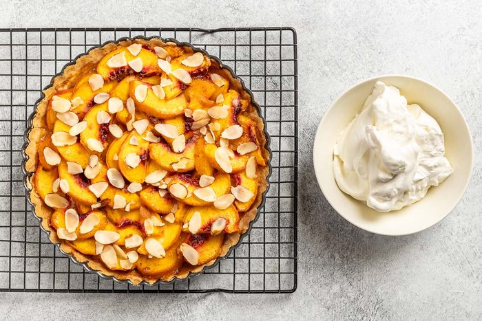 Taste of Home Peach Tart recipe photo of the baked tart with whipped cream.
