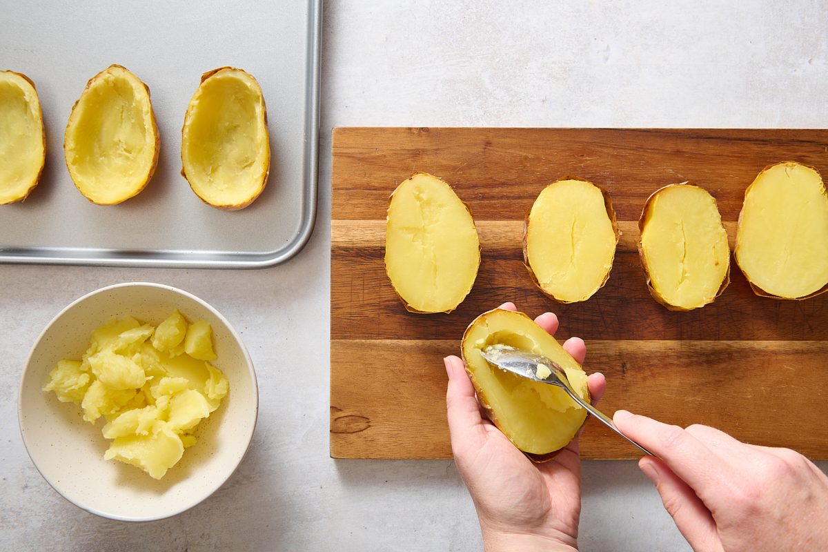 Scooping the flesh out of the cooked potatoes