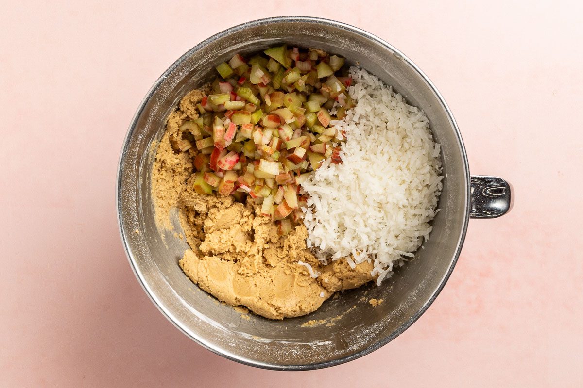 Taste of Home Rhubarb Cookies recipe photo of combining cream, shortening, eggs, flour, baking soda. rhubarb, shredded coconut, and salt in a bowl.