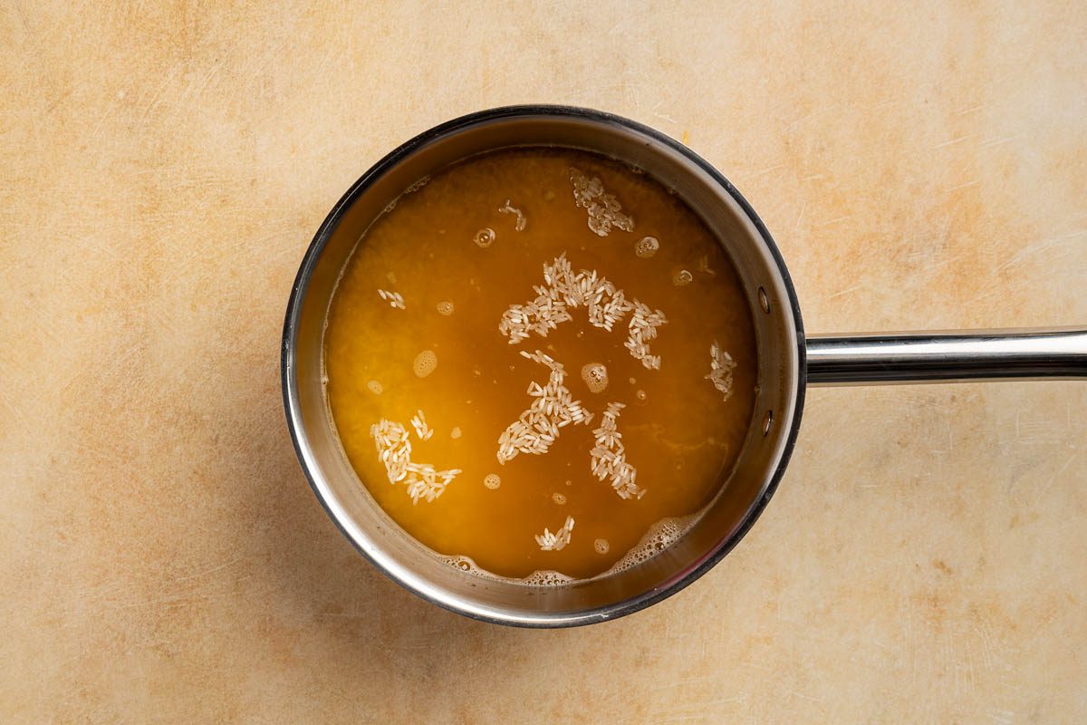 Taste of Home Rice Dressing recipe photo of the rice and chicken broth in a saucepan ready to boil.