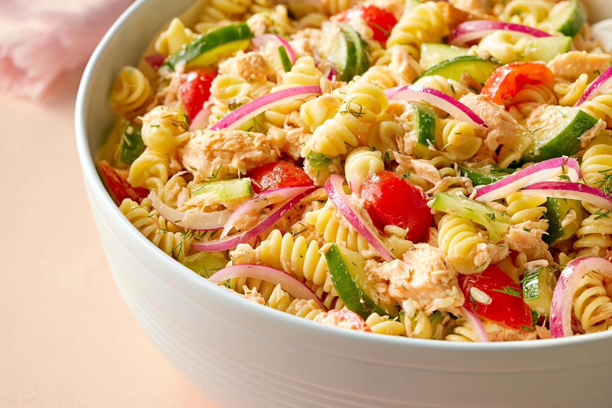 Close Shot of Salmon Pasta Salad Served in a large bowl on Beige Background