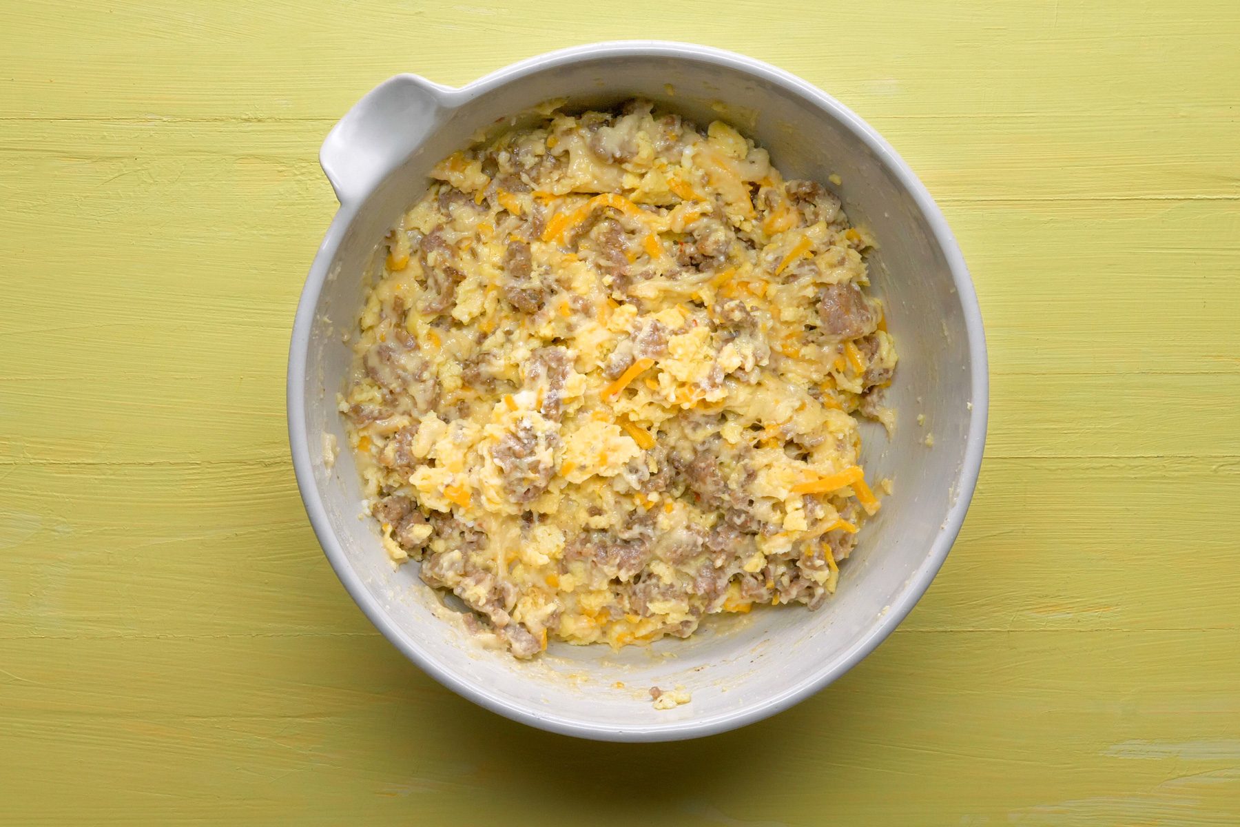 Top view shot of cheese, cooked sausage and scrambled eggs mixed together