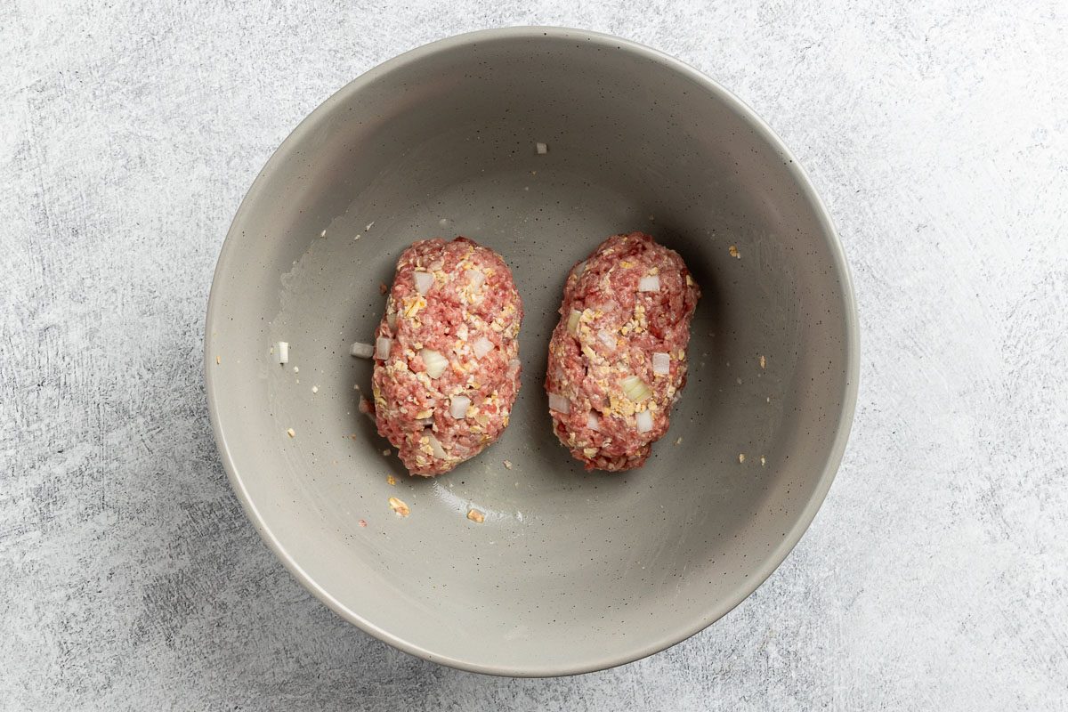 Taste of Home Skillet Meatloaf recipe photo of the ground beef, onion, oats, and salt combined and formed into loaves.