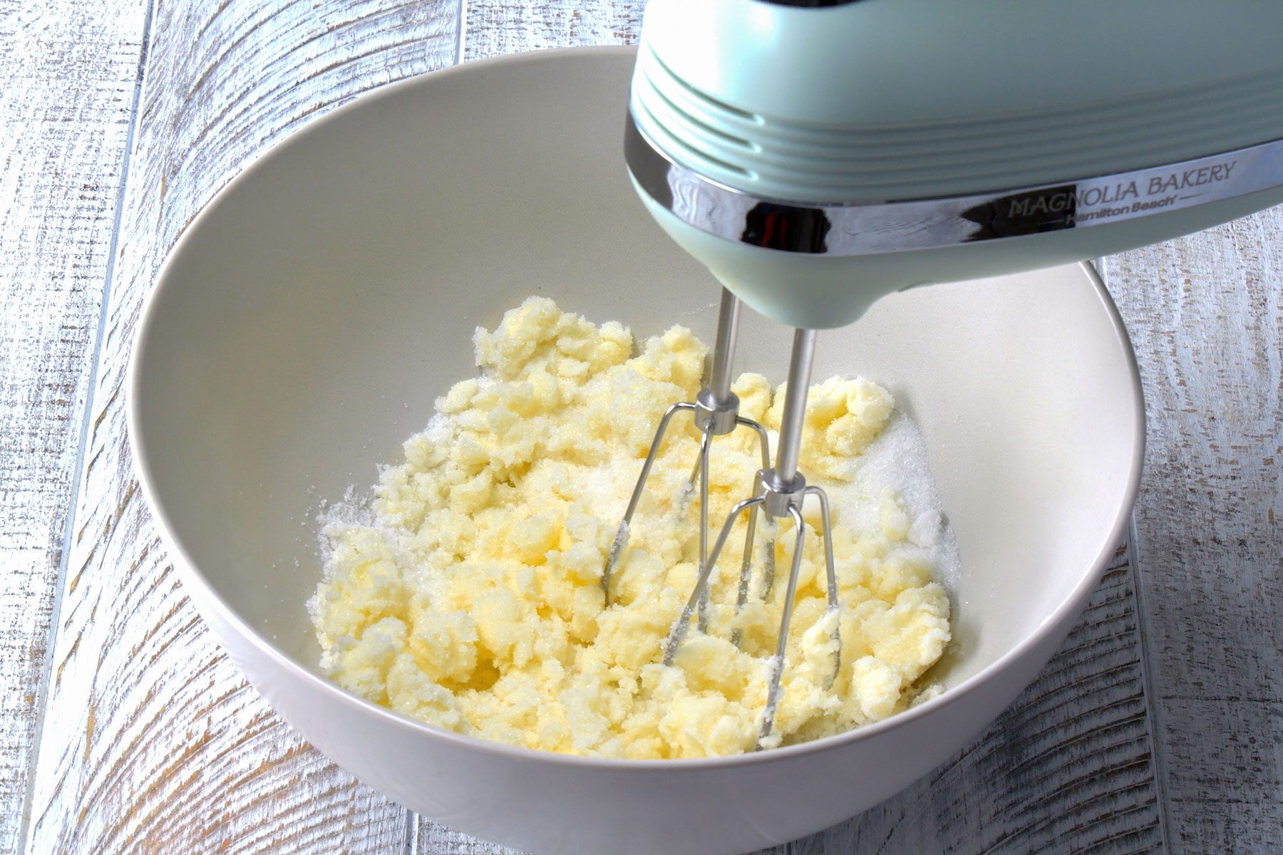 A stand mixer can be seen mixing butter and sugar in a bowl.