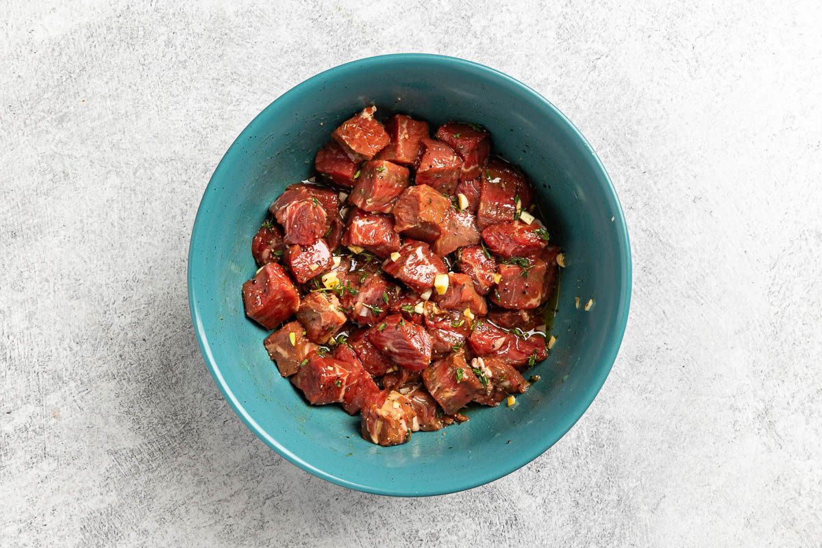 Taste of Home Steak and Potatoes recipe photo of the steak marinating in a large bowl.