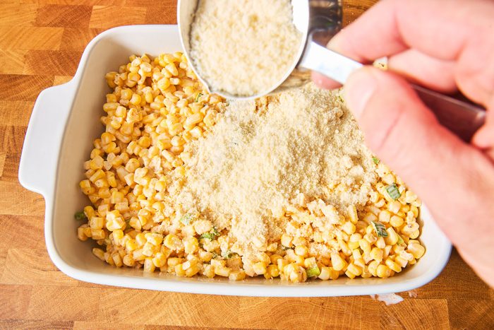 adding cheese to Mexican Street Corn Bake
