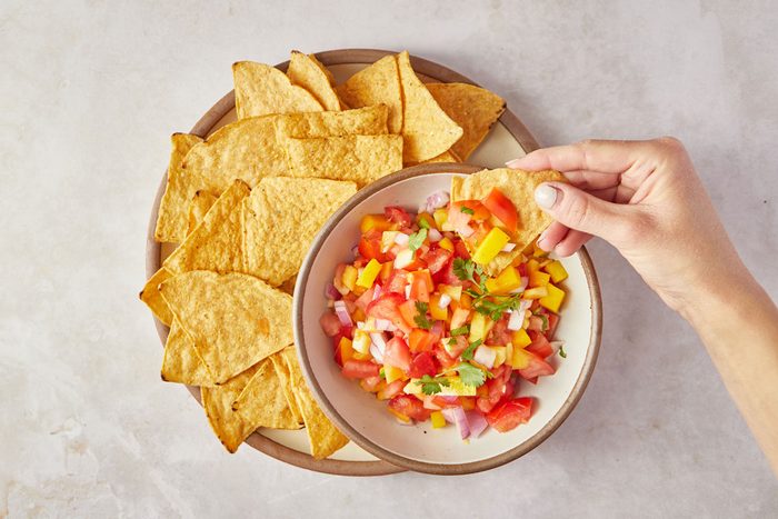 dipping chip in Peach Mango Salsa