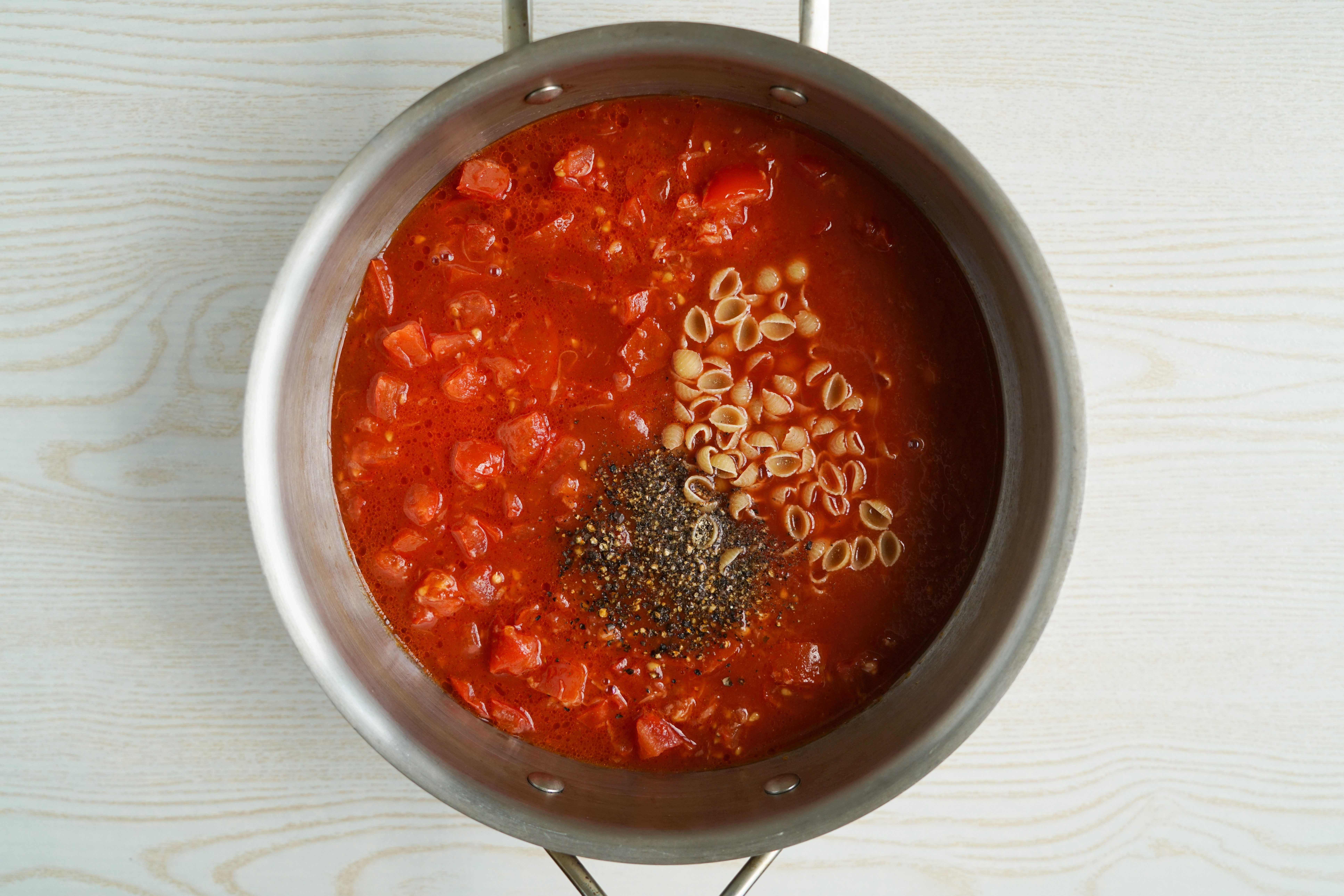 Adding pasta to Tomato Florentine Soup