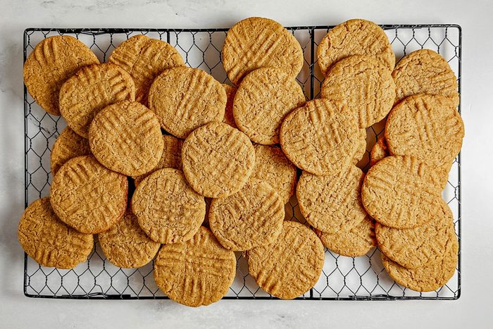 Taste of Home vegan peanut butter cookies on a wire cooling rack on a marble surface.