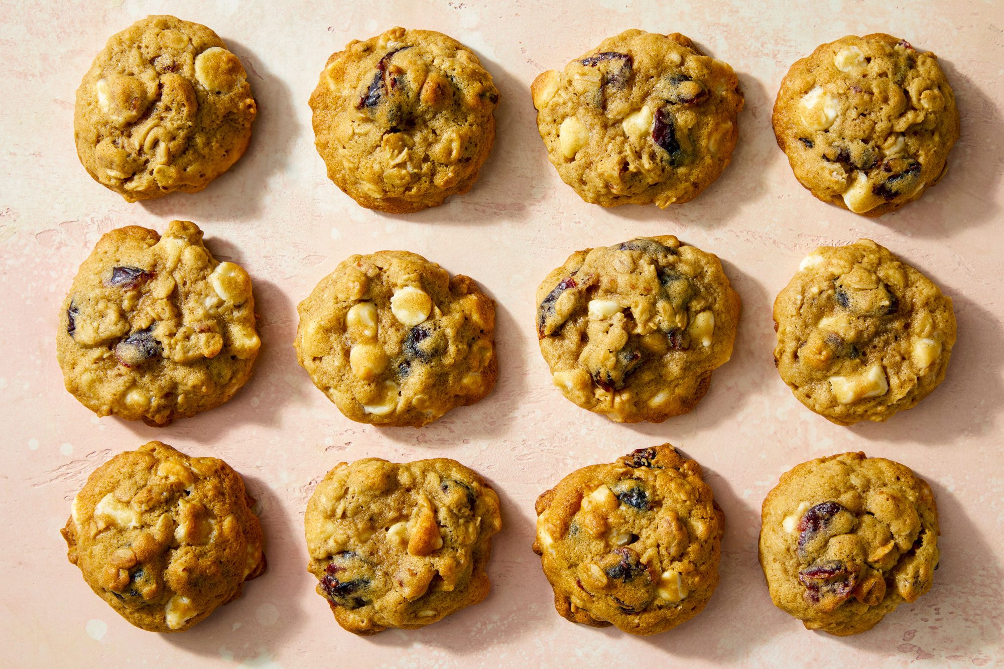 Overhead Shot of White Chocolate Cranberry Oatmeal Cookies on Pink Surface