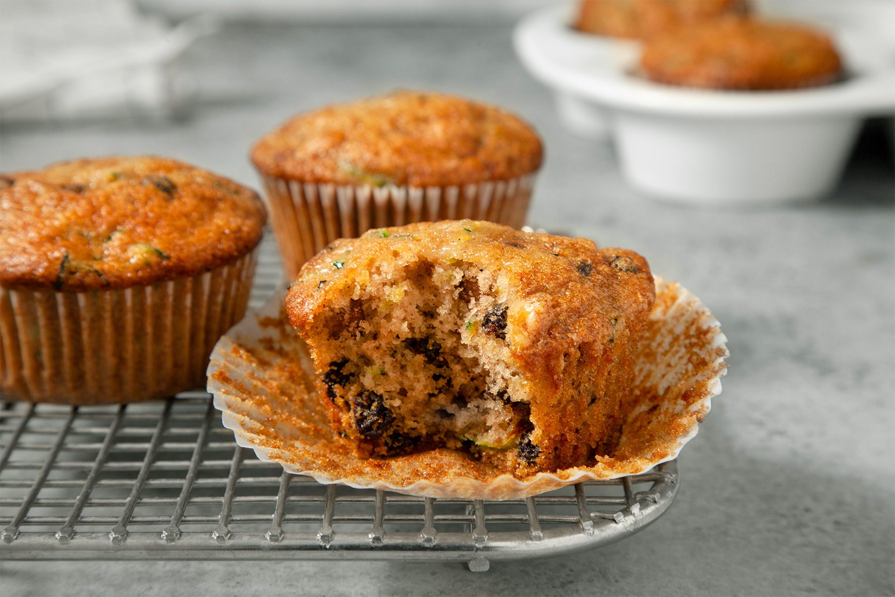 wide shot of zucchini muffins on a wired rack
