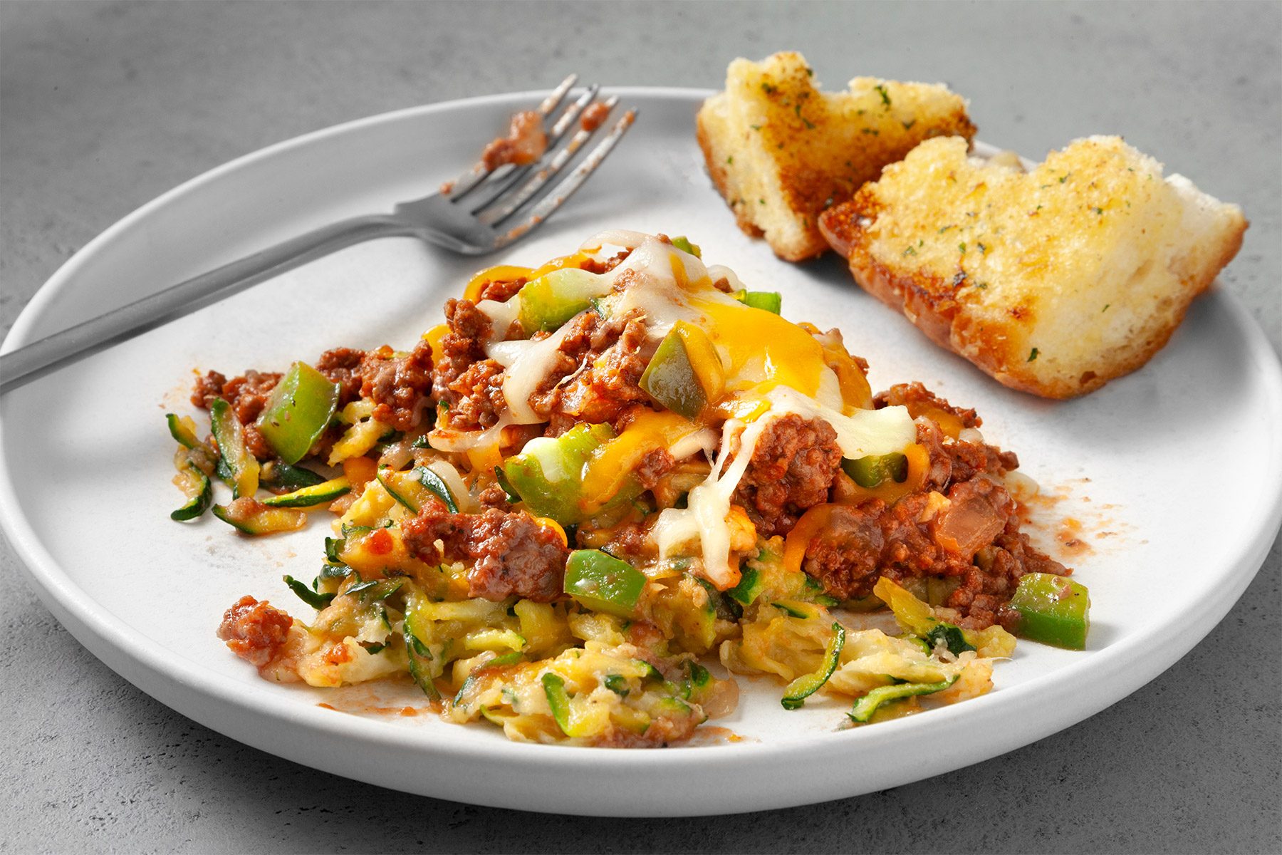 close shot of zucchini pizza casserole served with bread