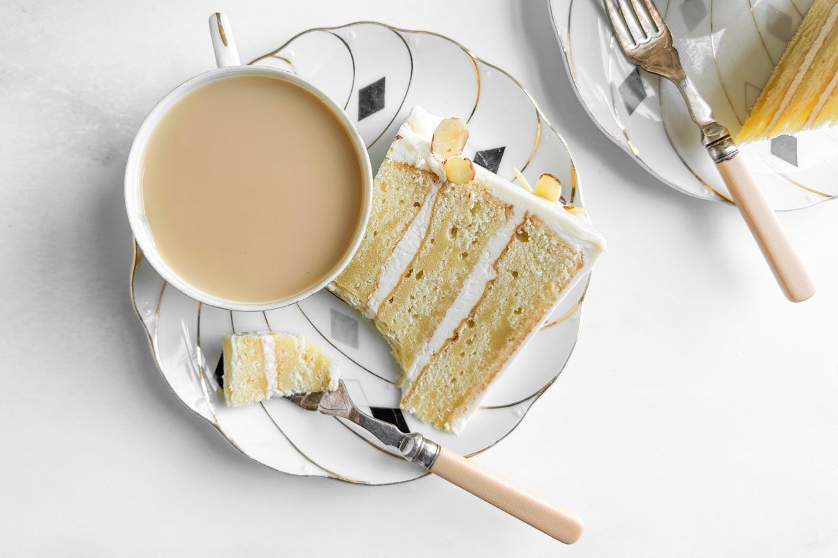 Taste of Home Amaretto Cake on cake plates with cups of tea
