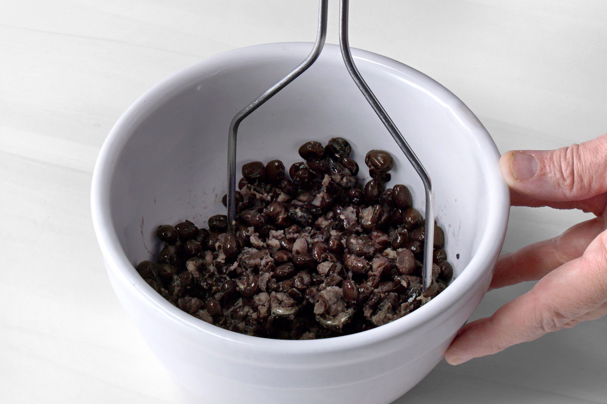 In a small bowl, mash 1 can black beans;