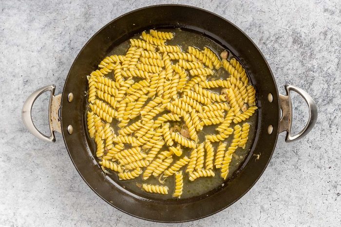 Taste of Home Chicken Pesto Pasta recipe photo of the pasta cooked in chicken broth in the skillet.