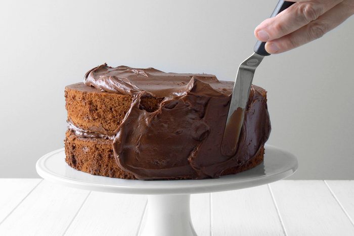 Frosting being applied to cake layers.