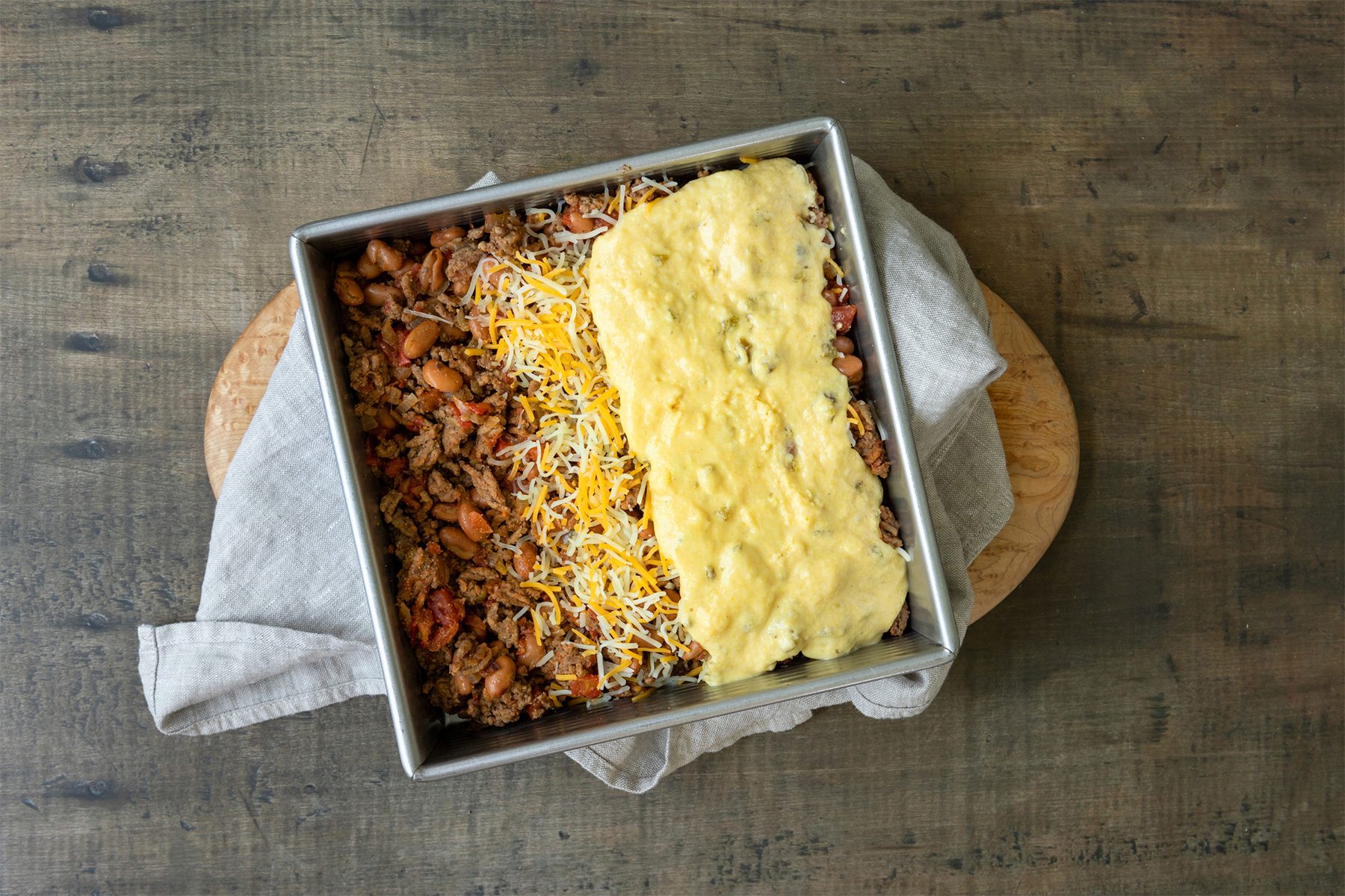 Pouring topping on top of the Casserole