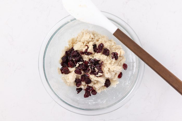 Scones dough being finalized with cranberries mixed in.