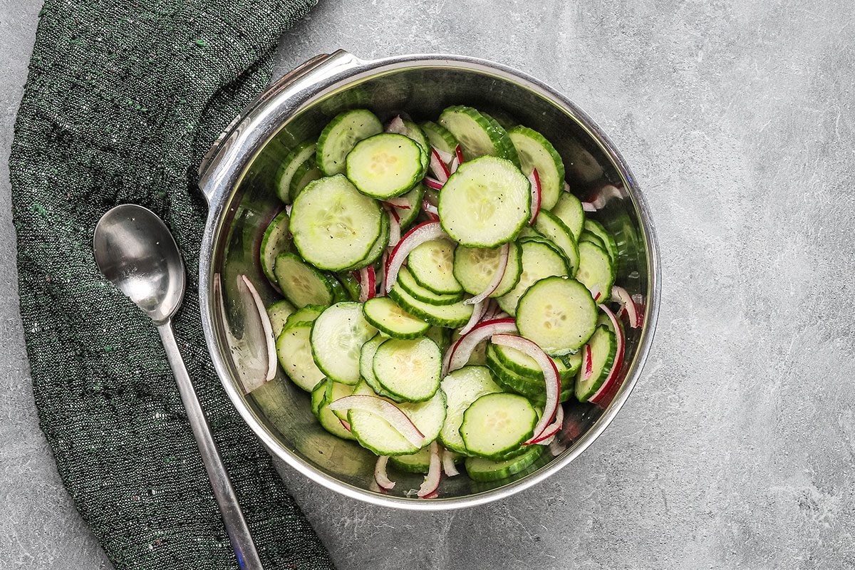 Cucumber and red onion salad preparation.