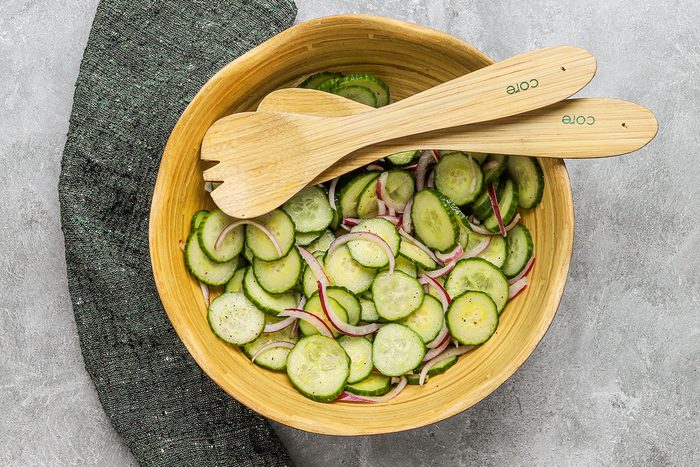 A salad bowl with cucumber and red onion salad.