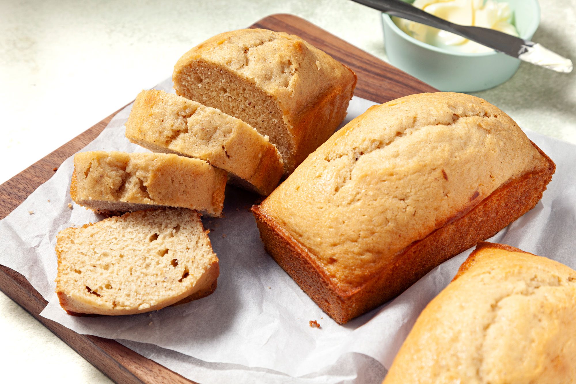 Eggnog Bread served on a wooden plank with butter