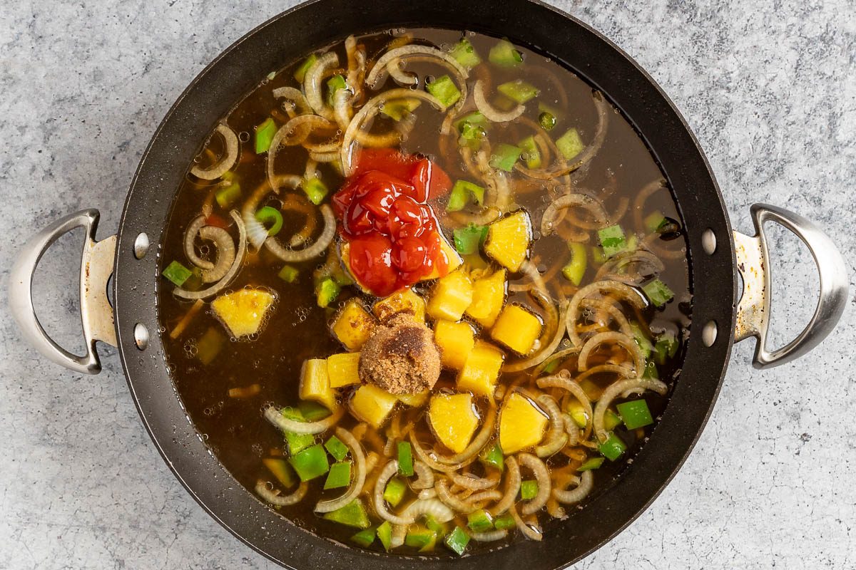 Taste of Home Hawaiian Pork Chops photo of the broth, pineapple, ketchup, brown sugar, and vinegar added to the skillet.