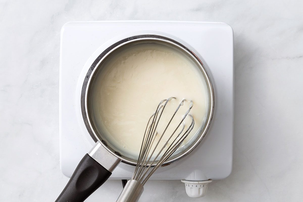 Flour, milk, and sugar combined in a heated saucepan for step one of Ho Ho Cake recipe for Taste of Home