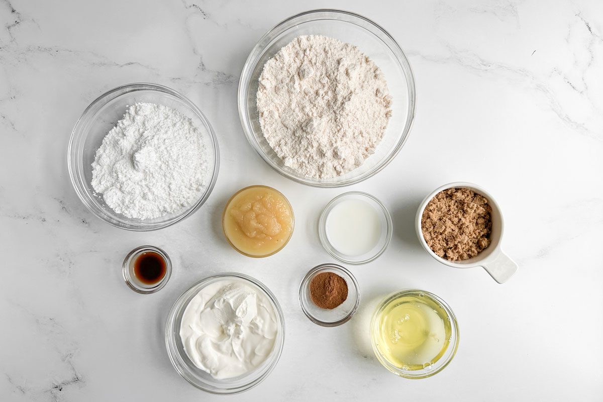 Ingredients for Taste of Home Honey Bun Cake in glass bowls on a marble surface