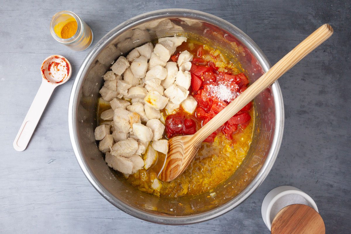 Step 2 of Taste of Home Instant Pot Chicken Curry is to Add the onion, curry, turmeric and cumin. Cook and stir until the onion is tender, which takes three to five minutes. Next, add the broth, stirring to loosen browned bits from pan. Then, stir in the tomatoes, tomato paste, garlic, ginger, sugar, chicken and salt.
