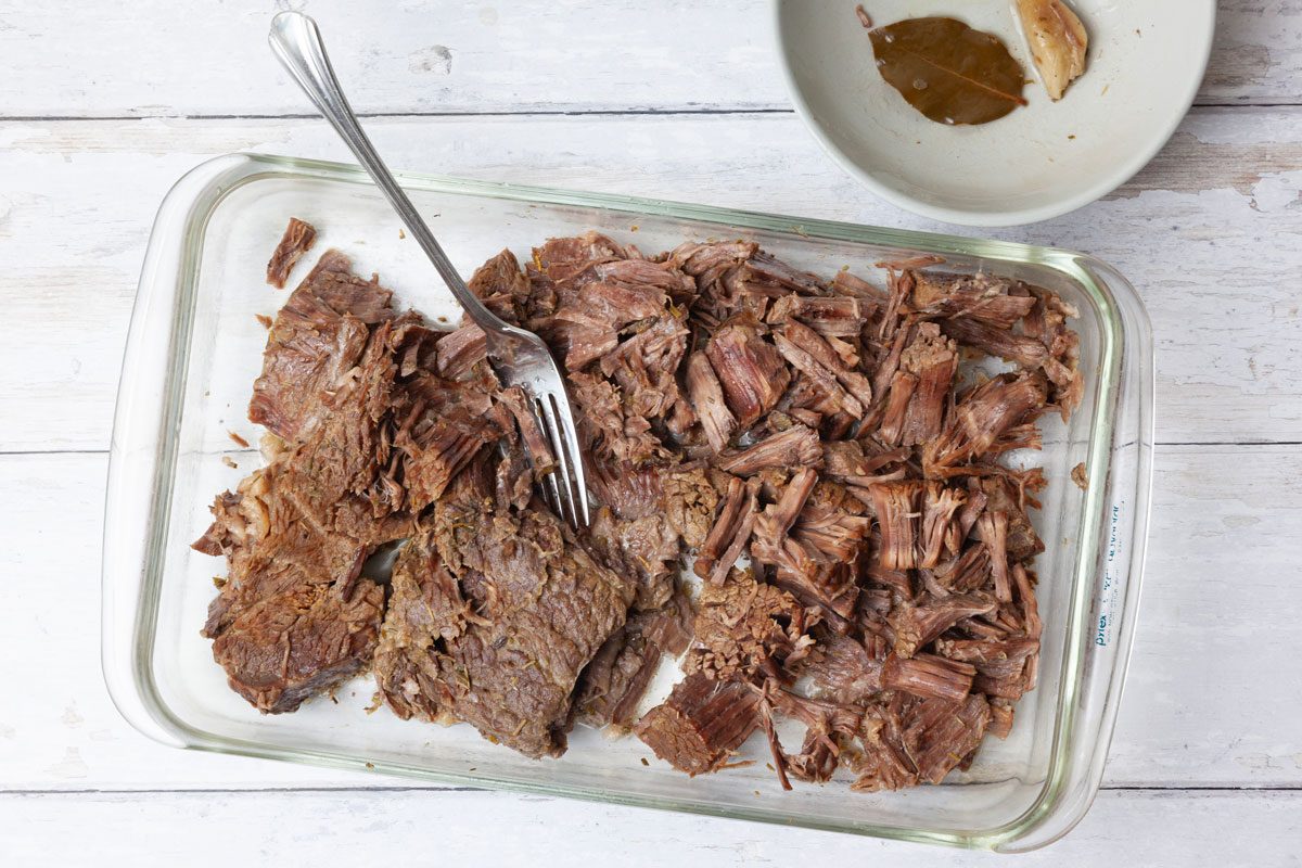 Step 3 of Taste of Home Instant Pot French Dip is to remove the beef from the Instant Pot—a thermometer inserted into the beef should read at least 145°F to ensure it's fully cooked. Let it cool slightly before shredding the beef using two forks. Discard any large pieces of fat.
