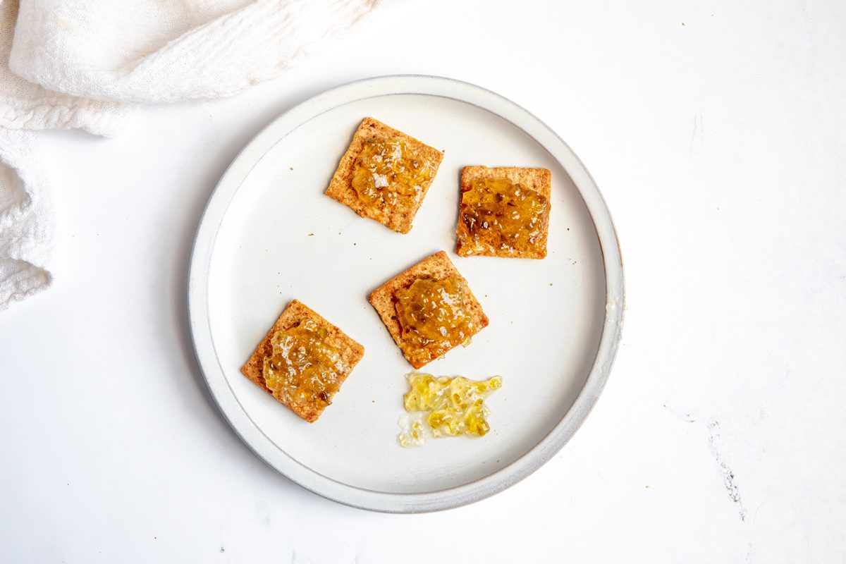 Overhead beauty shot for Taste of Home Jalapeno Jelly with crackers being eaten on a plate.