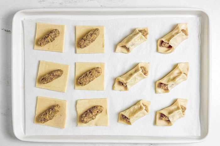 Unbaked Taste of Home Kolacky Cookies on a white baking sheet on a marble surface