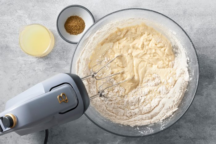 Overhead shot of combine flour; baking powder and salt; beat into egg mixture; beat in lemon zest and aniseed; blender; grey marble surface;