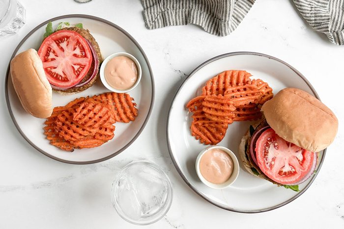 Taste of Home Lentil Burger on ceramic plates with waffle fries